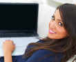 Young woman sitting on sofa using laptop
