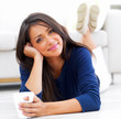 Pretty young woman lying and holding a coffee mug
