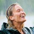 Happy woman enjoying in rain outdoors