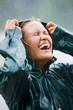 Happy woman enjoying in rain outdoors