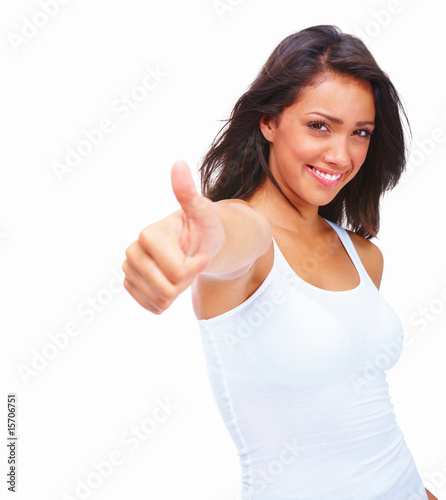 Photo: Happy young girl showing thumbs up sign isolated on white backgr Happy young girl showing thumbs up sign isolated on white backgr