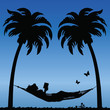 Photographie : Woman Reading in a Hammock Between Palm Tress