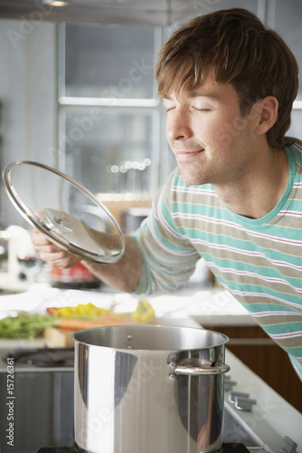 Photo: Man smelling aroma from cooking pot Man smelling aroma from cooking pot