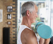 Man lifting dumbbells in living room