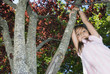 Girl swinging from tree branch