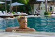 Blonde girl relaxing in water in the pool