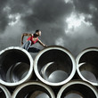 Runner leaning on large cylinders