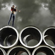 Woman stretching on top of large cylinders