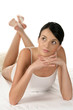 Happy woman lying down on bed with legs crossed Happy woman lying down on bed with legs crossed