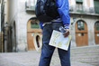 Man holding map hat and bottle of water outdoors