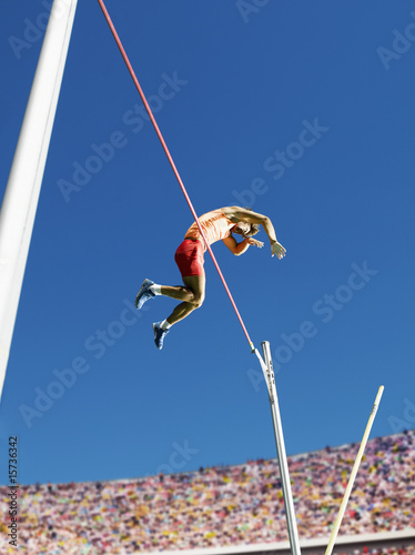 Foto: Athlete in mid air doing pole vault Athlete in mid air doing pole vault