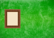 Grunge green stucco wall with empty picture frame