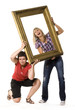 Two young women holding wooden frame Two young women holding wooden frame