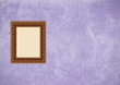 Grunge purple stucco wall with empty picture frame
