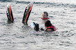 Man and woman swiming on water with skis