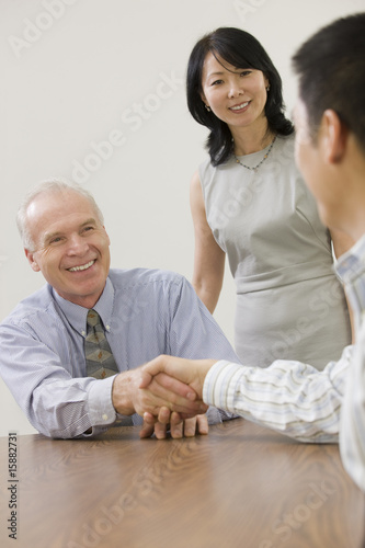 Photo: Team member being congratulated by managers. Team member being congratulated by managers.