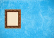 Grunge blue stucco wall with empty picture frame