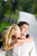 Young happy embracing couple walking together outdoors
