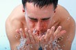 Young man washing face.
