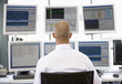 Stock Trader Looking At Multiple Monitors