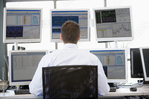 Photo: Stock Trader Looking At Multiple Monitors Stock Trader Looking At Multiple Monitors
