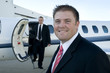 Businessmen standing in front of corporate jet