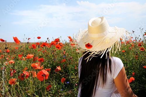 Photo: Young beautiful woman in poppy flowers Young beautiful woman in poppy flowers