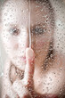 showering woman shot from behind glass showering woman shot from behind glass