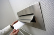 Human hand throwing letter in letterbox, close-up