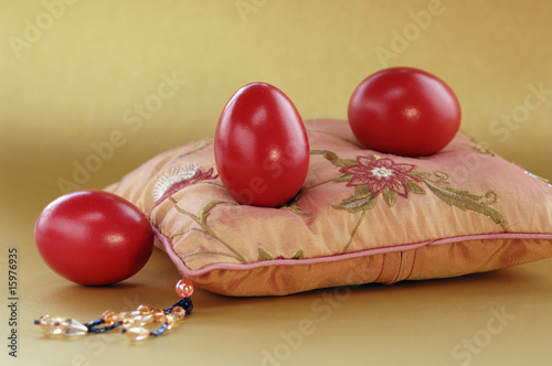Photo: Red Easter eggs on pink pillow, close-up Red Easter eggs on pink pillow, close-up