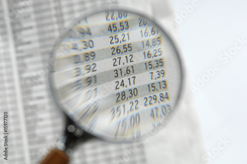 Photo: Stock quotations under magnifying glass, close-up Stock quotations under magnifying glass, close-up