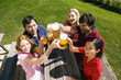Photo: Germany, Bavaria, Upper Bavaria, Cheerful people toasting each other in beer garden, elevated view Germany, Bavaria, Upper Bavaria, Cheerful people toasting each other in beer garden, elevated view