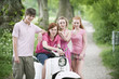 Germany, Bavaria, Four friends standing by moped, portrait