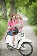 Germany, Bavaria, Young couple with map on motor scooter