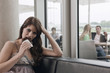 Germany, Cologne, Young woman eating a piece of cake, persons in background