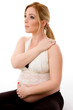 side pose of blonde pregnant female doing exercise