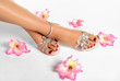 Beautiful woman legs with red manicure on the feet and flowers