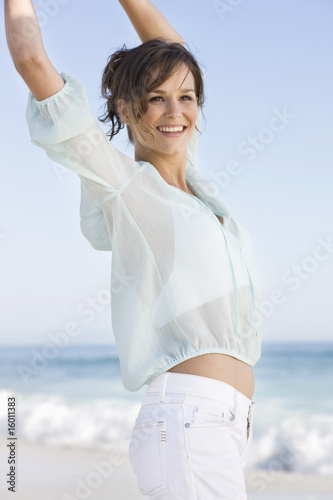 Photo: Woman jumping on the beach and smiling Woman jumping on the beach and smiling