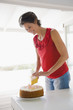 Woman cutting a cake and smiling