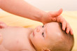Smiling baby and an adult 's hand.
