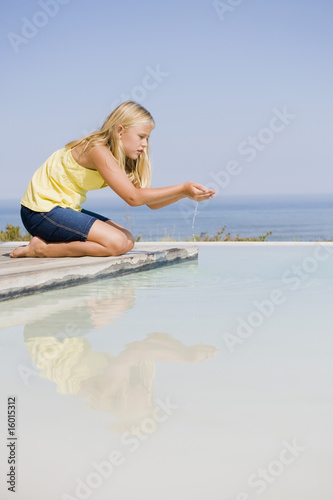 Photo: Girl playing on a platform at an infinity pool Girl playing on a platform at an infinity pool