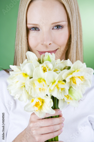 Photo: A portrait of a young blonde woman holding a bunch of daffodils A portrait of a young blonde woman holding a bunch of daffodils