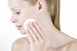 A portrait of a young woman cleansing her face