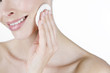 A portrait of a young woman cleansing her face