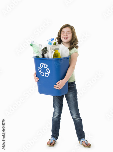 Photo: Pretty young girl holding blue recycle bin on white background Pretty young girl holding blue recycle bin on white background