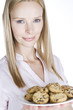 A young blonde woman holding a plate of cookies