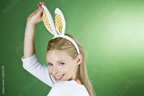 Photo: A young blonde woman wearing rabbit ears, smiling A young blonde woman wearing rabbit ears, smiling