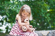 Photo: Adorable little girl giving her teddy bear a kiss on the head. Adorable little girl giving her teddy bear a kiss on the head.