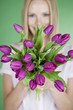 A young woman holding a bunch of purple tulips