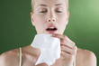 A portrait of a young woman sneezing